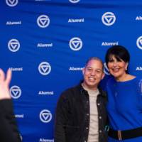 President Mantella poses with a grad in front of the photo backdrop